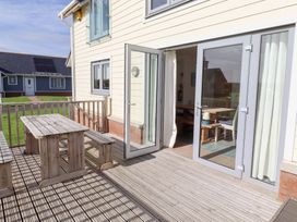 An outdoor patio with a table and benches at The Beach House in Beadnell