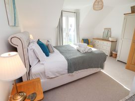 A bedroom with a bed, nightstand, and chest of drawers at The Beach House (Beadnell)