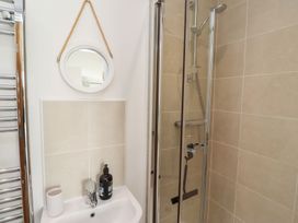 A bathroom featuring a shower, mirror, and sink at The Beach House (Beadnell)