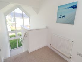 A staircase with a window and painting at The Beach House in Beadnell