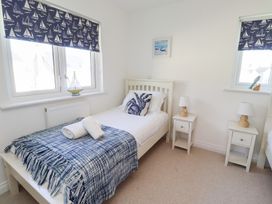 A bedroom with two single beds and bedside tables at The Beach House (Beadnell)