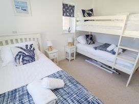 A bedroom with a double bed and a bunk bed at The Beach House (Beadnell)