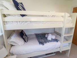 A bedroom with a bunk bed and bedding at The Beach House (Beadnell)