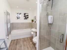 A bathroom with a bathtub and shower at The Beach House (Beadnell)