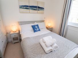 A bedroom with a bed and bedside lamps at The Beach House (Beadnell)