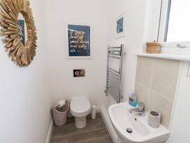 A bathroom with a mirror, toilet, and sink at The Beach House (Beadnell)