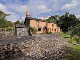 A house with stone walls and a pathway at Hart Head Farm in Rydal near Ambleside