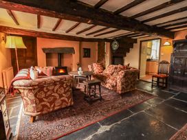 A living room with a fireplace and seating area at Hart Head Farm in Rydal near Ambleside
