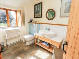 A bathroom with a sink, toilet, and window at Hart Head Farm in Rydal near Ambleside