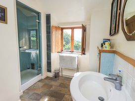 A bathroom with a shower, sink, and window at Hart Head Farm in Rydal near Ambleside