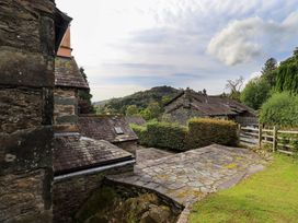 An outdoor view of stone buildings and greenery at Hart Head Farm in Rydal near Ambleside