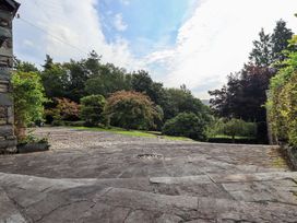 A garden area with stone pavement and trees at Hart Head Farm Rydal near Ambleside