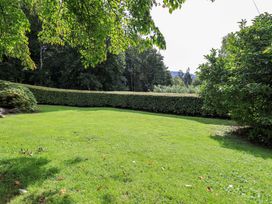 A garden with grass and surrounding hedges at Hart Head Farm in Rydal near Ambleside