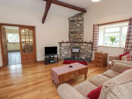 A living room with a fireplace and sofa at Bryn Caled in Llanarmon near Y Ffor