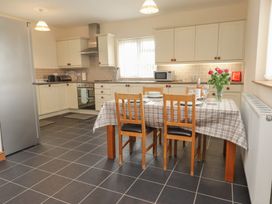 A kitchen with a dining table and chairs at Bryn Caled Llanarmon near Y Ffor