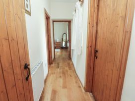 A hallway with wooden doors and a mirror at Bryn Caled in Llanarmon near Y Ffor