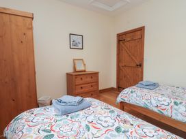 A bedroom with two beds and wooden furniture at Bryn Caled in Llanarmon near Y Ffor