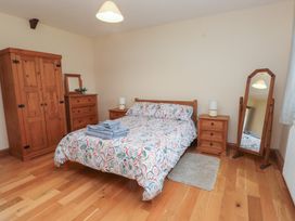 A bedroom with a bed and wardrobe at Bryn Caled in Llanarmon near Y Ffor