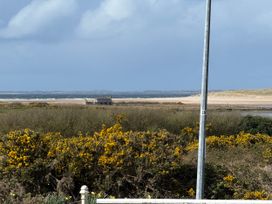 A view of a beach with a house and gorse bushes at Geesala