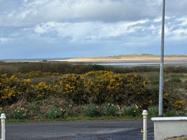 A view of the beach and sea with bushes in the foreground at Geesala