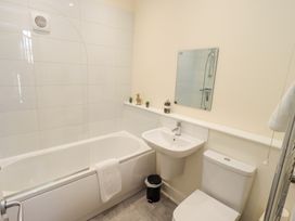 A bathroom with a bathtub a sink a toilet and a mirror at 4 Martindales Yard in Kendal