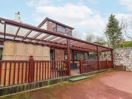 An outdoor area with a covered pergola and wooden decking at Acorns in Holywell
