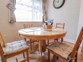 A dining room with a circular table and chairs at Acorns in Holywell
