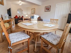 A dining room with a round table and chairs at Acorns in Holywell