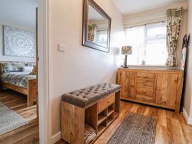 A hallway with a bench and a mirror at Acorns in Holywell