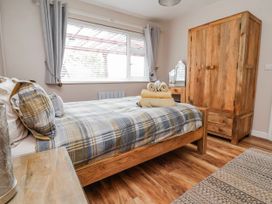 A bedroom with a bed and wardrobe at Acorns in Holywell
