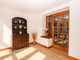 A living room with a shelf and a door at Cromlech Cottage at Cromlech Manor Farm in Tyn-y-Gongl near Benllech