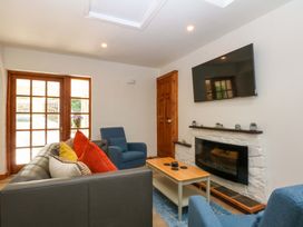 A living room with a sofa and television at Cromlech Cottage at Cromlech Manor Farm Tyn-y-Gongl near Benllech