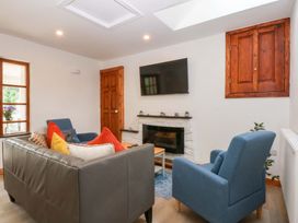 A living room with a tv and fireplace at Cromlech Cottage at Cromlech Manor Farm, Tyn-y-Gongl near Benllech
