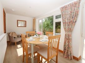 A dining room with a table and chairs at Cromlech Cottage at Cromlech Manor Farm near Tyn-y-Gongl