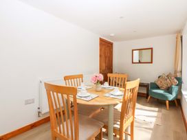 A dining room with a table and chairs at Cromlech Cottage at Cromlech Manor Farm Tyn-y-Gongl near Benllech