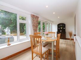 A dining room with a table and chairs at Cromlech Cottage at Cromlech Manor Farm, Tyn-y-Gongl near Benllech