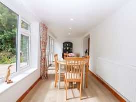 A dining room with chairs and a table at Cromlech Cottage at Cromlech Manor Farm near Benllech