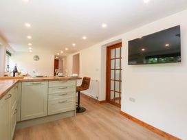 A kitchen with a counter and bar stool at Cromlech Cottage at Cromlech Manor Farm, Tyn-y-Gongl near Benllech