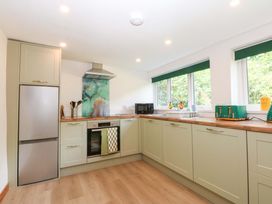 A kitchen with appliances and windows at Cromlech Cottage at Cromlech Manor Farm Tyn-y-Gongl near Benllech