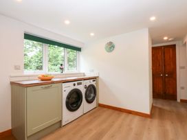 A laundry room with washing machines and natural light at Cromlech Cottage at Cromlech Manor Farm in Tyn-y-Gongl near Benllech