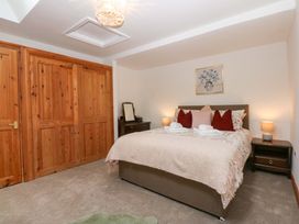 A bedroom with a bed and nightstand at Cromlech Cottage at Cromlech Manor Farm Tyn-y-Gongl near Benllech