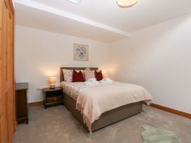 A bedroom with a bed and nightstand at Cromlech Cottage at Cromlech Manor Farm Tyn-y-Gongl near Benllech
