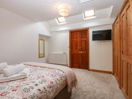 A bedroom with a bed and wardrobe at Cromlech Cottage at Cromlech Manor Farm Tyn-y-Gongl near Benllech