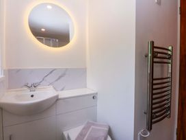 A bathroom with a sink and a mirror at Cromlech Cottage at Cromlech Manor Farm Tyn-y-Gongl near Benllech
