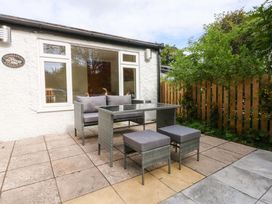 An outdoor dining area with a table and chairs at Cromlech Cottage at Cromlech Manor Farm Tyn-y-Gongl near Benllech