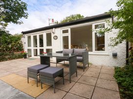 An outdoor area with seating and table at Cromlech Cottage at Cromlech Manor Farm in Tyn-y-Gongl near Benllech