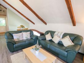 A living room with a green sofa and a coffee table at Loft apartment in Llandysul