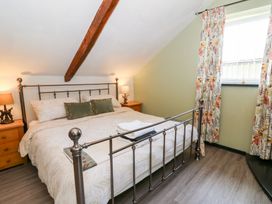A bedroom with a bed and bedside table at Loft apartment in Llandysul