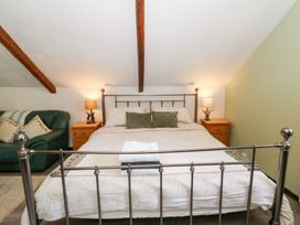 A bedroom with a bed and couch at Loft apartment in Llandysul