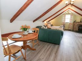 A living room with a table and chairs and a couch at Loft apartment in Llandysul